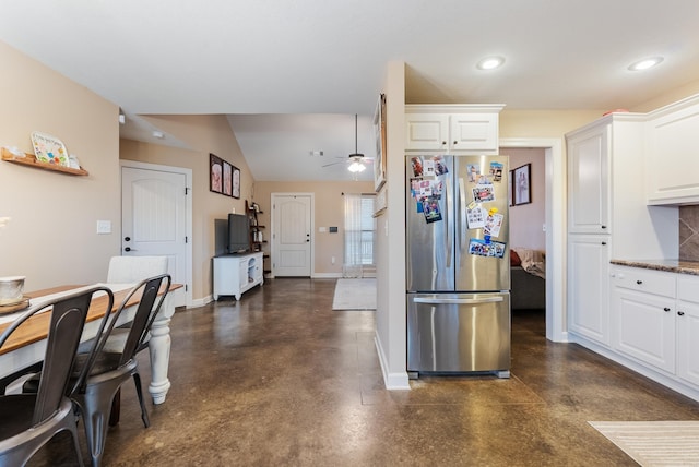 kitchen with stainless steel fridge, white cabinetry, and ceiling fan