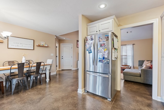 kitchen featuring white cabinetry and stainless steel refrigerator