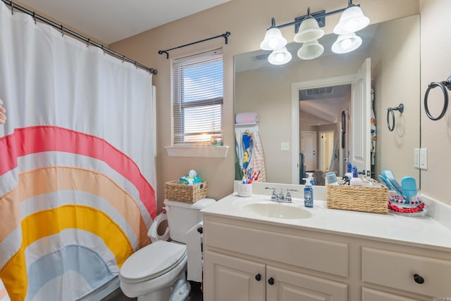 bathroom featuring vanity, a shower with shower curtain, and toilet