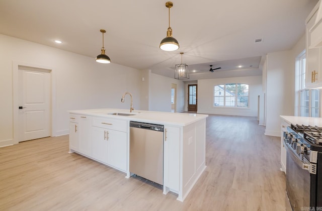 kitchen with a center island with sink, sink, ceiling fan, white cabinetry, and stainless steel appliances