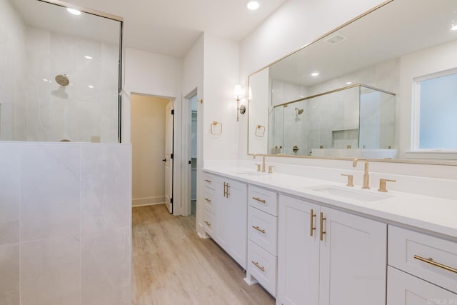 bathroom with vanity, wood-type flooring, and an enclosed shower