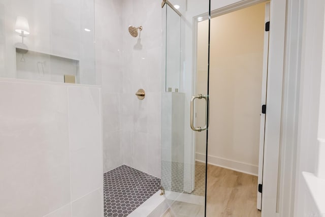 bathroom featuring a shower with door and wood-type flooring