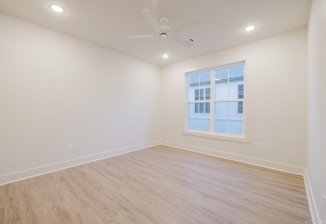 empty room with ceiling fan and light hardwood / wood-style floors