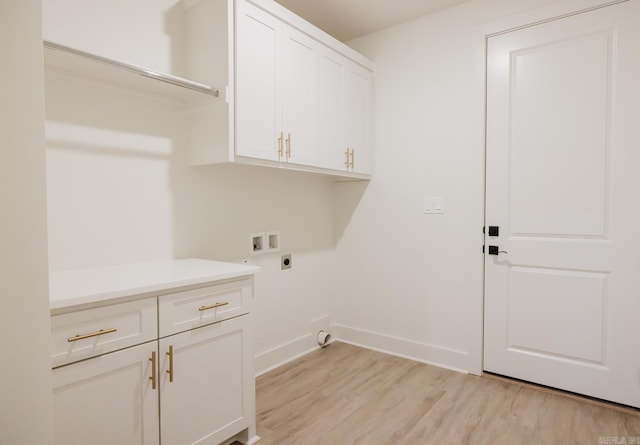 laundry room with electric dryer hookup, cabinets, light hardwood / wood-style flooring, and washer hookup