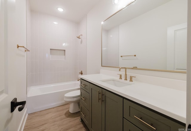 full bathroom featuring vanity, hardwood / wood-style flooring, toilet, and tiled shower / bath