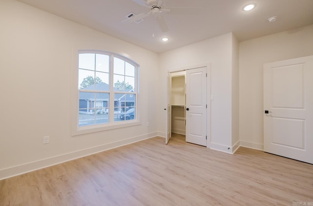 unfurnished bedroom featuring ceiling fan, a closet, and light hardwood / wood-style flooring