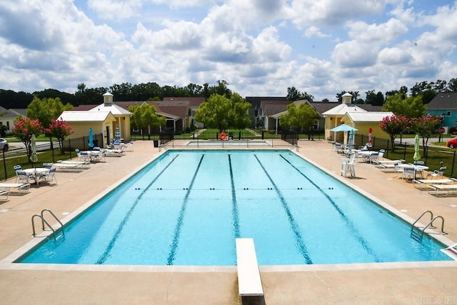 view of pool featuring a diving board and a patio