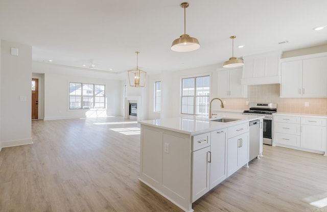 kitchen with a kitchen island with sink, white cabinetry, and stainless steel appliances