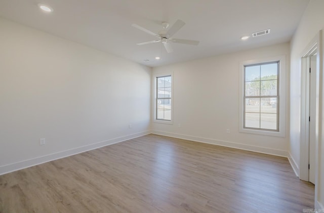 empty room with ceiling fan and light hardwood / wood-style floors