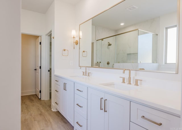 bathroom with vanity, wood-type flooring, and a shower with shower door