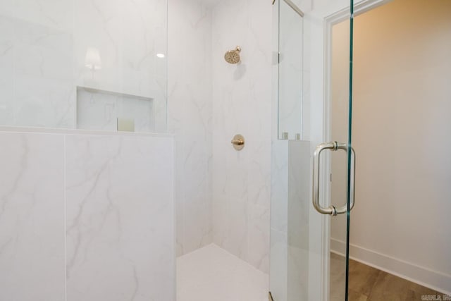 bathroom with an enclosed shower and hardwood / wood-style flooring