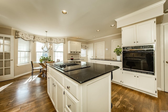 kitchen with white cabinets, a center island, and black oven