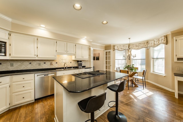 kitchen with pendant lighting, a center island, white cabinets, sink, and appliances with stainless steel finishes