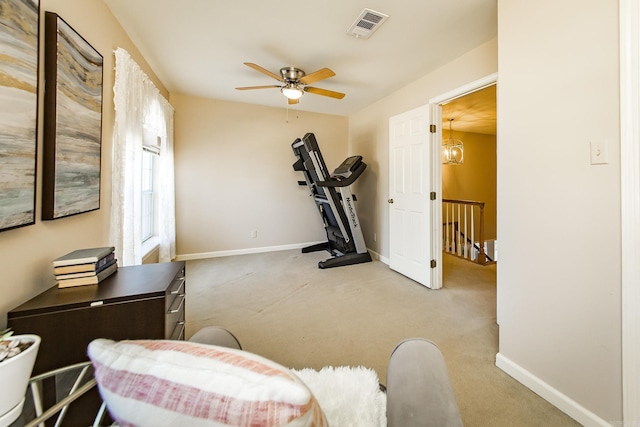 exercise room featuring light carpet and ceiling fan with notable chandelier