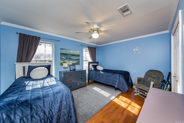 bedroom with hardwood / wood-style flooring, ceiling fan, and ornamental molding