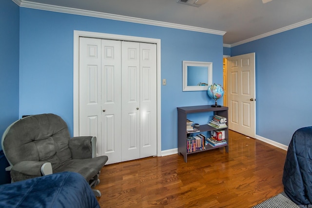 bedroom featuring dark hardwood / wood-style flooring, ornamental molding, and a closet