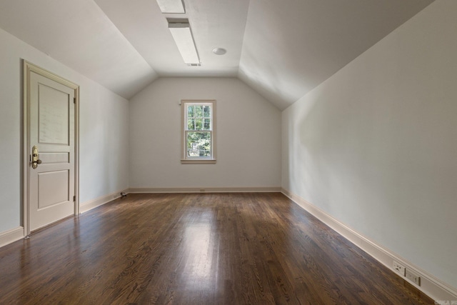 additional living space with dark hardwood / wood-style flooring and vaulted ceiling