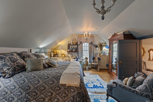 bedroom with a chandelier, light wood-type flooring, and vaulted ceiling