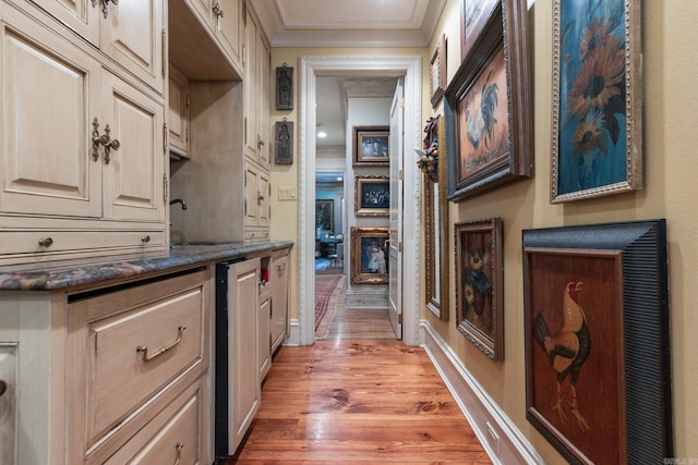 kitchen featuring sink, wood-type flooring, and crown molding