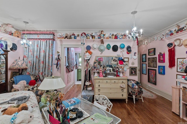 bedroom with a notable chandelier, dark hardwood / wood-style floors, and ornamental molding