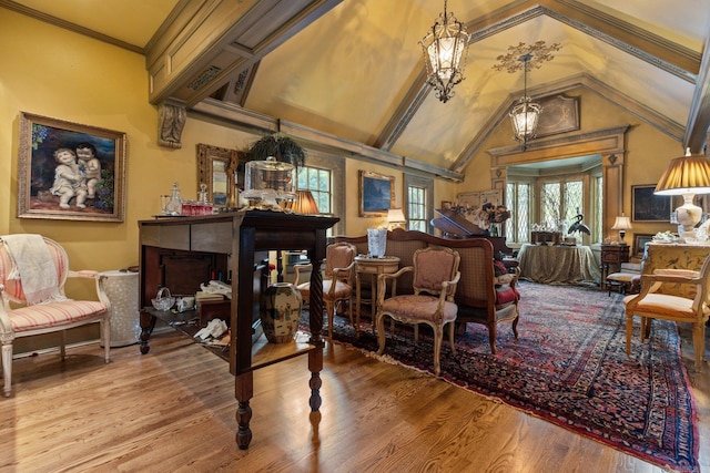 sitting room with wood-type flooring, lofted ceiling, and crown molding