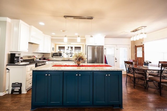 kitchen featuring appliances with stainless steel finishes, a kitchen island, blue cabinets, and pendant lighting