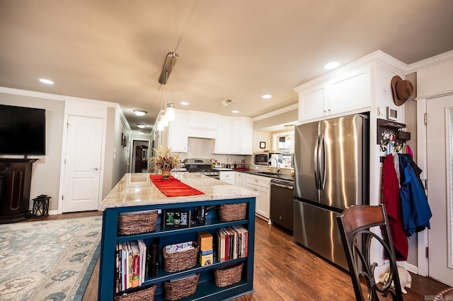 kitchen with decorative light fixtures, light stone countertops, white cabinetry, and appliances with stainless steel finishes