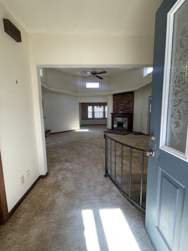 carpeted living room featuring a fireplace and ceiling fan