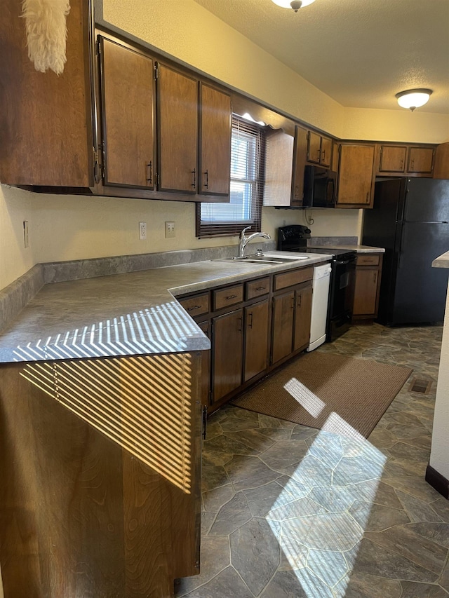 kitchen featuring sink, black appliances, and a textured ceiling