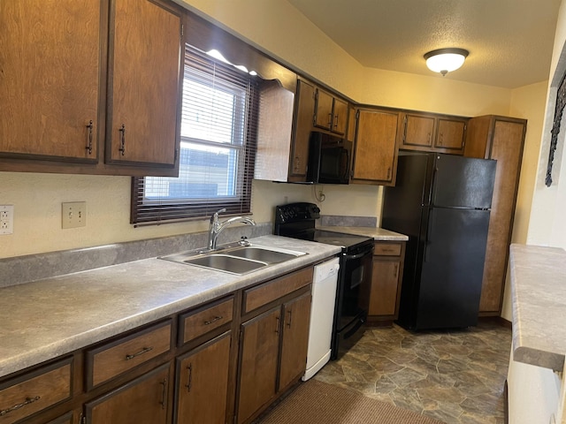 kitchen with sink, black appliances, and a textured ceiling