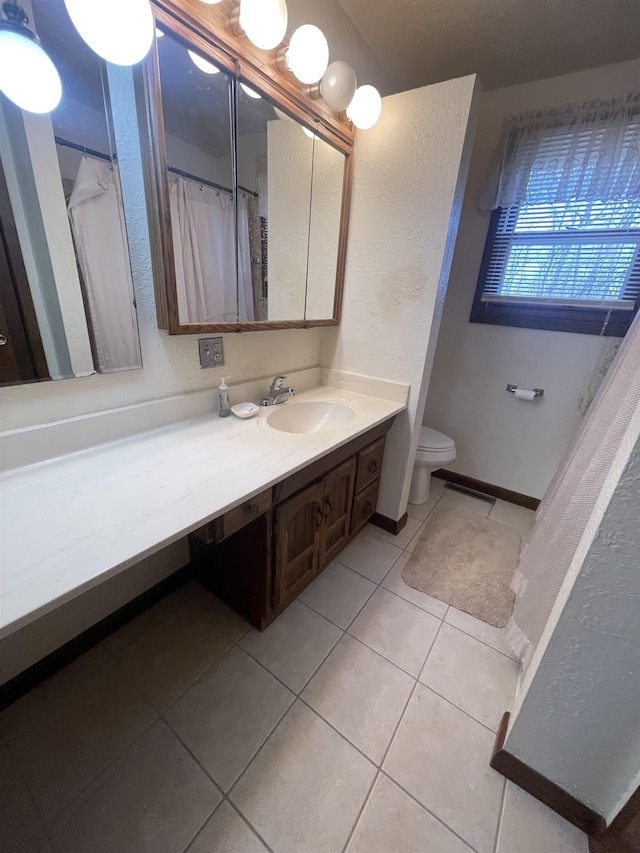 bathroom featuring tile patterned flooring, vanity, and toilet