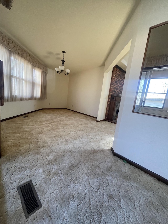 interior space featuring a fireplace, plenty of natural light, and an inviting chandelier