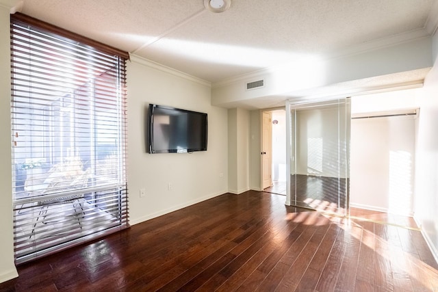 unfurnished living room featuring wood-type flooring, ornamental molding, and a textured ceiling