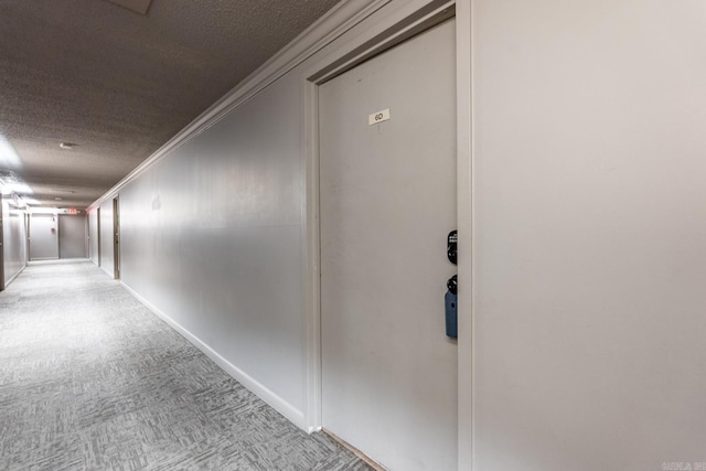 hallway with crown molding, light carpet, and a textured ceiling