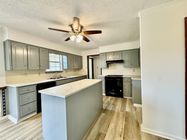 kitchen with ceiling fan, light hardwood / wood-style flooring, a textured ceiling, a kitchen island, and black appliances