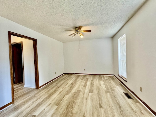 spare room with ceiling fan, light wood-type flooring, and a textured ceiling