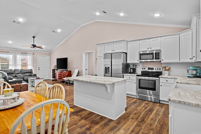 kitchen with appliances with stainless steel finishes, backsplash, light stone counters, sink, and white cabinetry