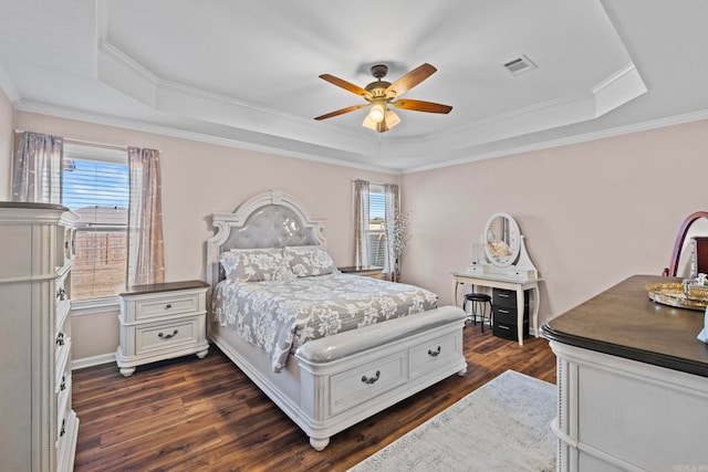 bedroom with dark wood-type flooring, a raised ceiling, ceiling fan, and crown molding