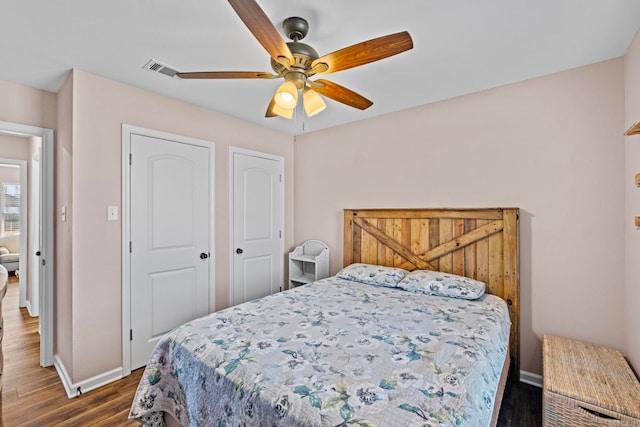 bedroom with ceiling fan and dark wood-type flooring