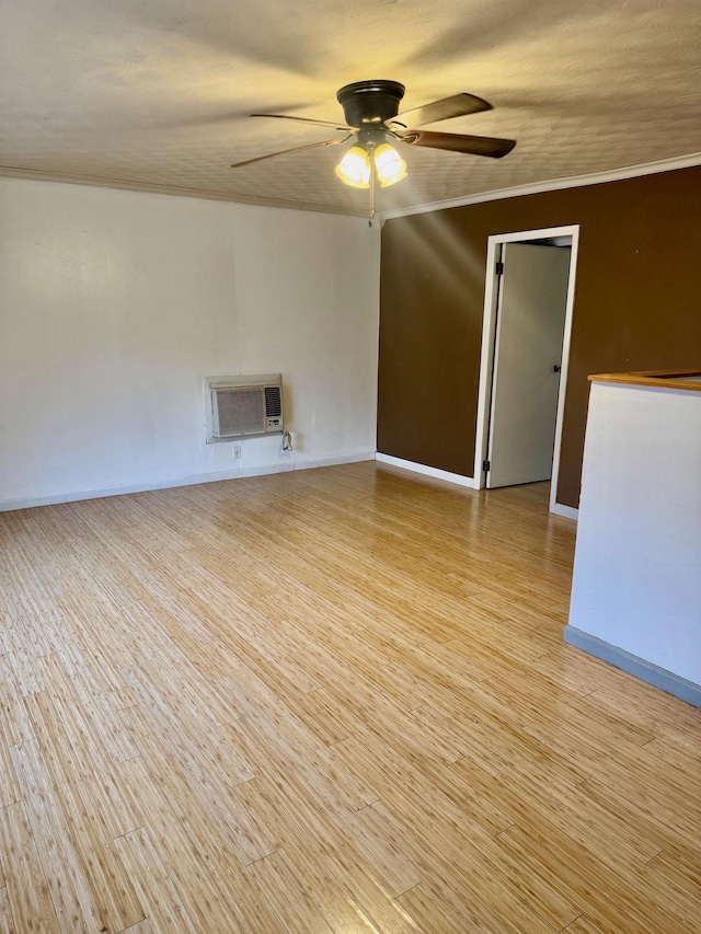 empty room with light wood-type flooring, heating unit, ceiling fan, and ornamental molding