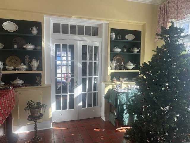 entryway with built in shelves and french doors