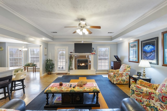 living room featuring a raised ceiling, crown molding, and a textured ceiling