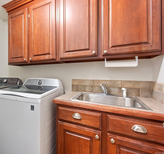 laundry room featuring washer and dryer, cabinets, and sink