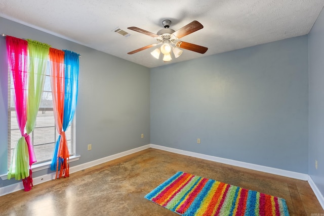 empty room featuring a textured ceiling, concrete floors, and ceiling fan