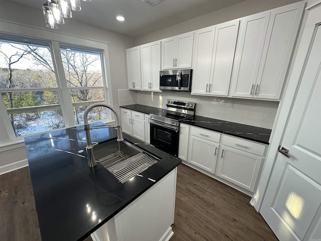 kitchen featuring backsplash, dark hardwood / wood-style floors, white cabinetry, and stainless steel appliances