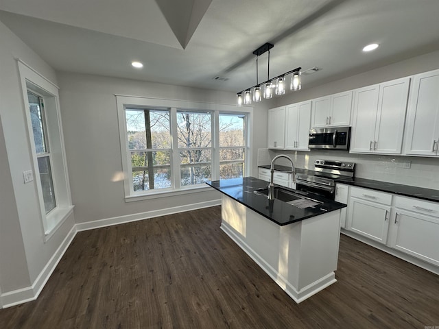 kitchen featuring white cabinets, appliances with stainless steel finishes, pendant lighting, and sink