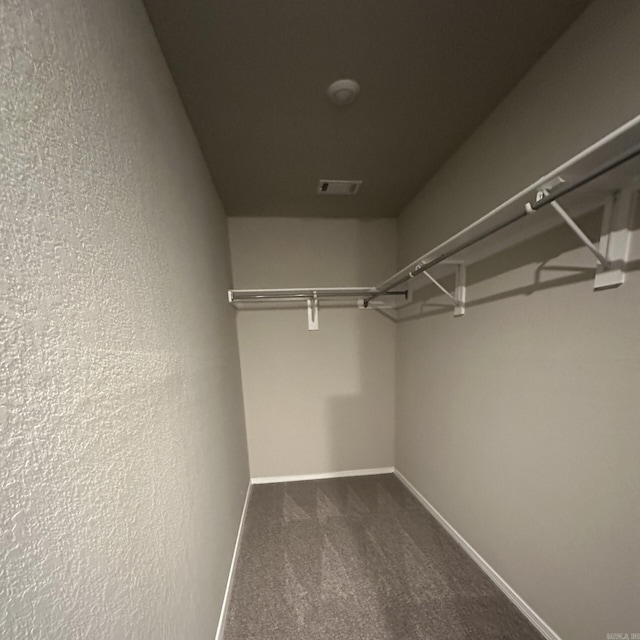 walk in closet with visible vents and carpet