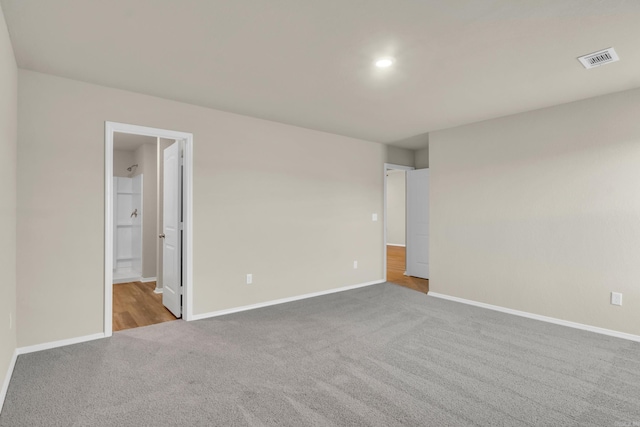 unfurnished room featuring visible vents, baseboards, and carpet flooring