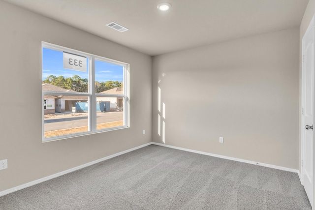 unfurnished room with visible vents, baseboards, and carpet flooring