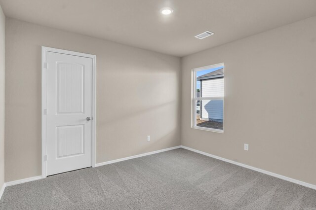 carpeted spare room with baseboards and visible vents